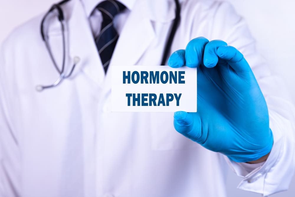 Doctor man put a card with the text HORMONE THERAPY in his pocket.