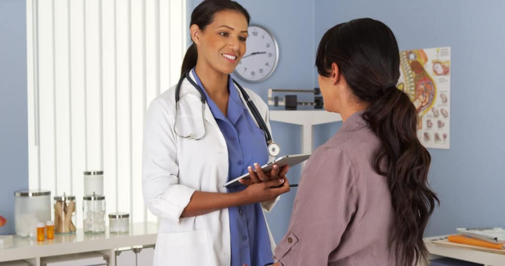 Doctor in appointment with female patient to discuss PMDD and DIM I3C supplements as potential solution