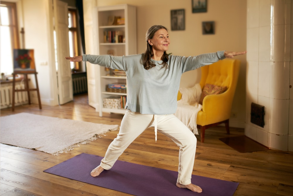 Healthy older woman doing yoga while feeling better after managing musculoskeletal syndrome