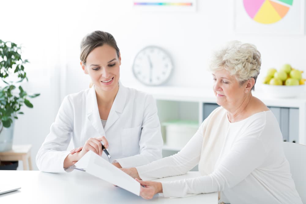 Doctor speaking with older female patient to discuss supplements to balance vitamin d deficiency