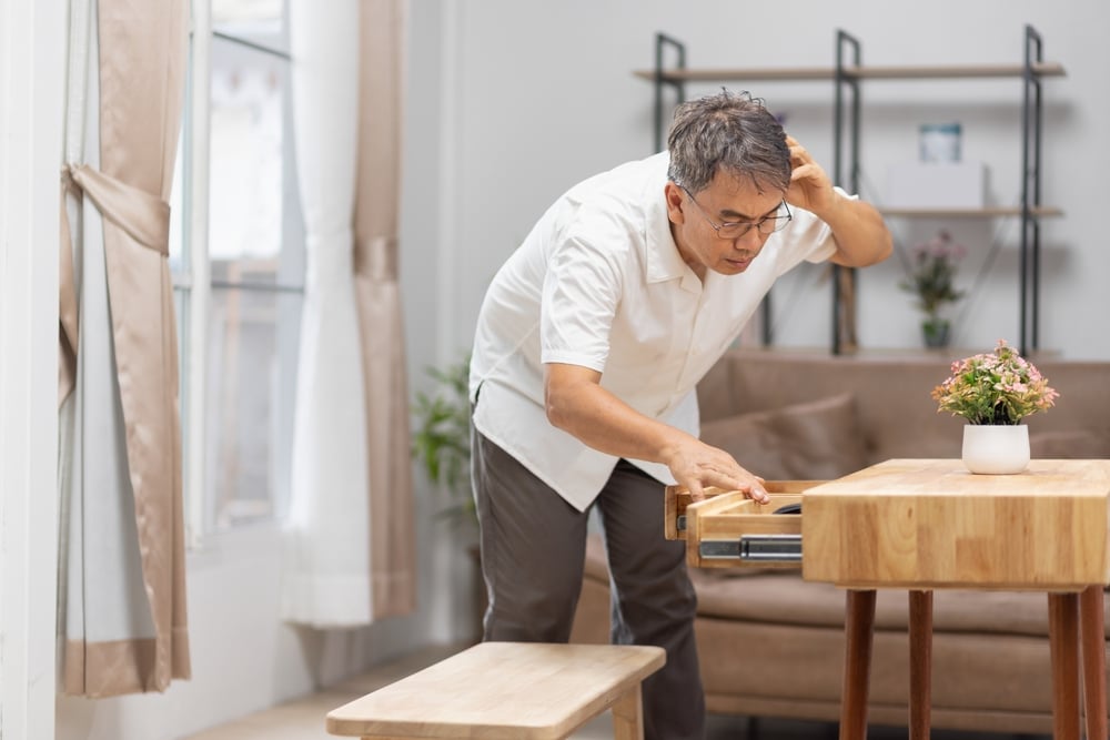 Man searching desk after he forgot where he put something due to brain fog and hormonal imbalances.