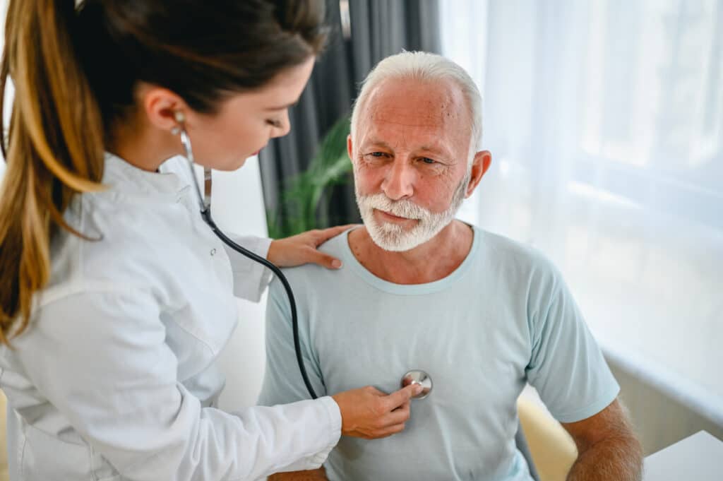 Doctor listening to man's heartbeat to evaluate heart health