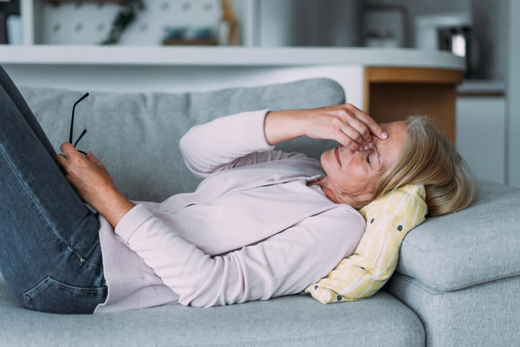 Woman resting with fatigue and brain fog, representing symptoms that may be associated with low pregnenolone.