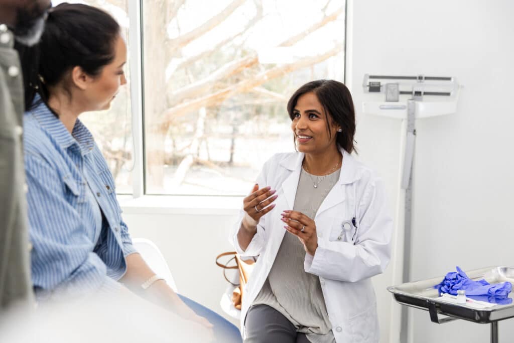 Healthcare provider discussing hormone lab results with a patient during a clinical evaluation.